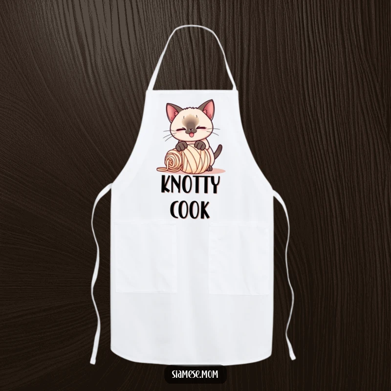 Funny Kawaii Siamese cat apron, playful smirk, pouncing on a rolled-up ball of yarn, a humorous and practical kitchen accessory.