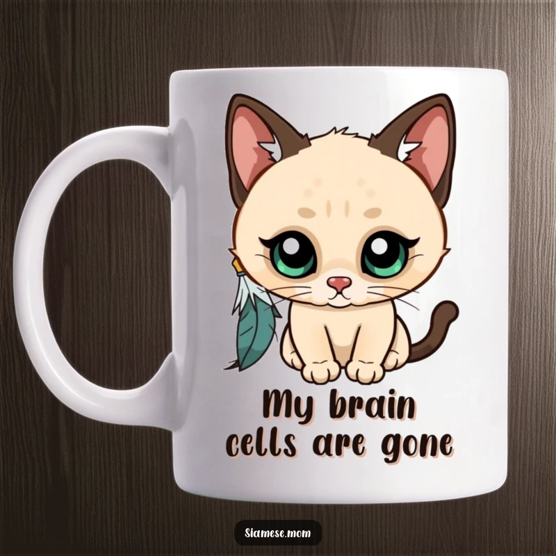 Funny Kawaii Siamese cat mug, wide-eyed and curious, playfully batting at a dangling feather, capturing pure feline enchantment and joy.