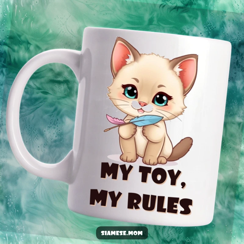 Funny Kawaii Siamese Kitten Mug grinning mischievously, clutching a feather playfully, ready for a good time.