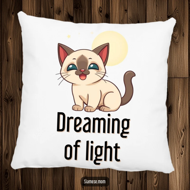 Funny stylized Siamese cat happily batting at glowing moonbeams, depicted on a soft decorative pillow.