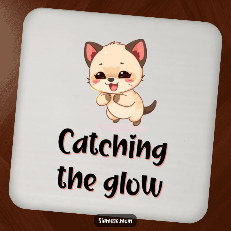 Funny Siamese cub giggling while chasing a shimmering light beam, a humorous and protective drink coaster for any surface.