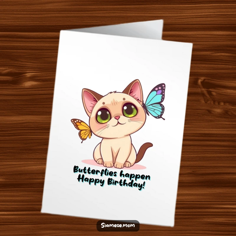 Funny free printable birthday card: Kawaii Siamese cat with big eyes playfully batting at a colorful butterfly, ready to celebrate.