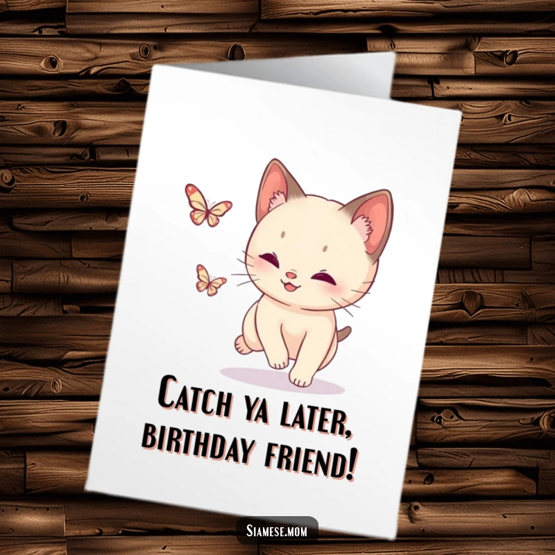 Funny Free Printable Birthday Card: A playful Siamese cat leaping to catch a tiny, sparkling butterfly mid-air.