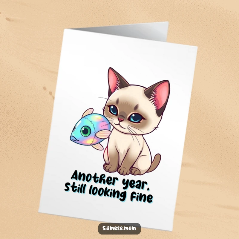 Funny Free Printable Birthday Card: An elegant Siamese cat playfully batting at a glowing holographic fish, celebrating joyfully.