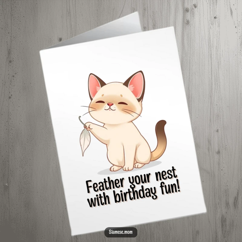 Funny Free Printable Birthday Card: A Siamese cat intently bats at a slowly falling feather, capturing playful birthday moments.