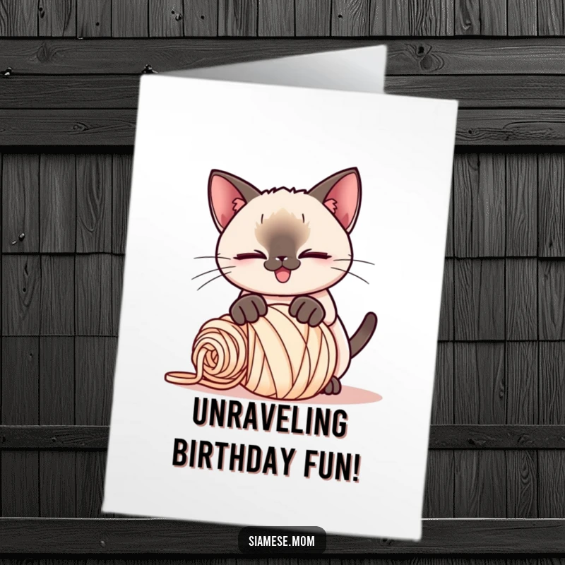Funny Free Printable Birthday Card: Kawaii Siamese cat with a playful smirk pounces on a rolled-up ball of yarn, full of mischief.